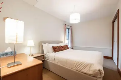 a bedroom with a bed and a table with a lamp at Blueberry Hill Estates 3180 by Outpost Whistler in Whistler