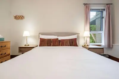 a bedroom with a white bed and a window at Blueberry Hill Estates 3180 by Outpost Whistler in Whistler