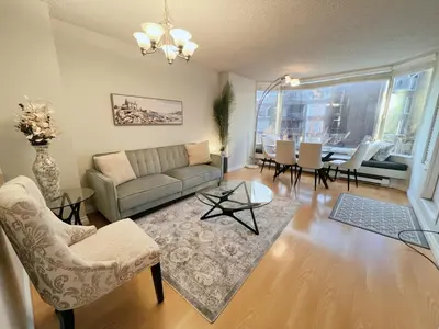 a living room with a couch and a table at Beautiful 2 Beds Dwtn apt Free Parking King Bed in Vancouver