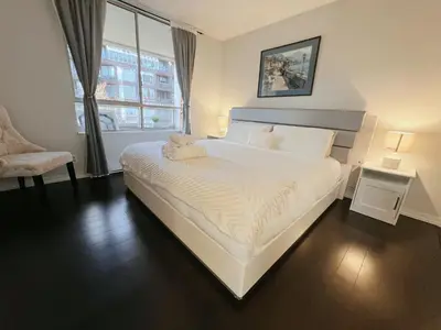 a bedroom with a white bed with a stuffed animal on it at Beautiful 2 Beds Dwtn apt Free Parking King Bed in Vancouver