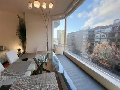 a room with a large window with tables and chairs at Beautiful 2 Beds Dwtn apt Free Parking King Bed in Vancouver
