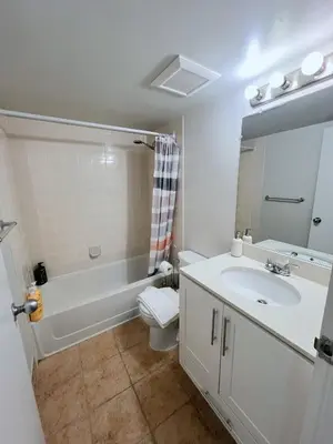 a bathroom with a sink and a tub and a toilet at Beautiful 2 Beds Dwtn apt Free Parking King Bed in Vancouver
