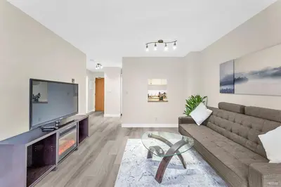 a living room with a couch and a big screen tv at Beautiful City Two Beds Suite with Free Parking in Vancouver
