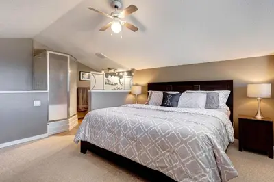 a bedroom with a bed and a ceiling fan at Cozy Condo with Epic Mountain Views, Parking, Air Con in Canmore