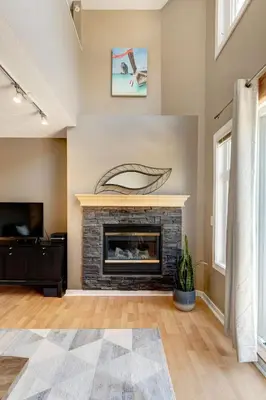 a living room with a fireplace and a tv at Cozy Condo with Epic Mountain Views, Parking, Air Con in Canmore