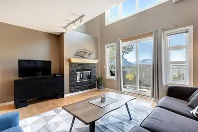 a living room with a couch and a fireplace at Cozy Condo with Epic Mountain Views, Parking, Air Con in Canmore