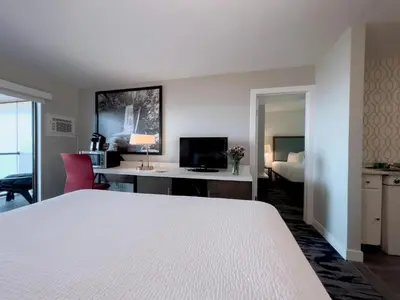 a hotel room with a bed and a desk with a computer at The Oceanside, a Coast Hotel in Sechelt
