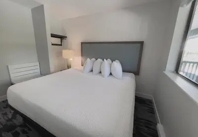 a bedroom with a white bed with three pillows at The Oceanside, a Coast Hotel in Sechelt