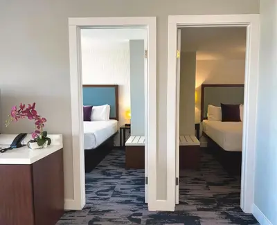 a hotel room with two beds and two mirrors at The Oceanside, a Coast Hotel in Sechelt