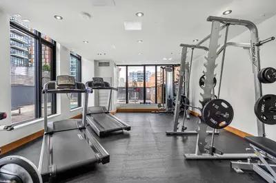 a gym with two treadmills and two machines at Poolside Bliss - 22 FL w Tower Views! FREE Banff Pass, Gym, Parking, Summer Outdoor Pool! in Calgary