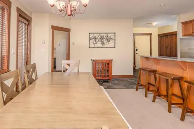 a kitchen with a long wooden table in a room at Stonegate Resort Unit A206 in Kelowna