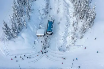 a group of people on a ski lift in the snow at Winter Escape On Perfection - Ski In Out, Pool & Hot Tub in Big White