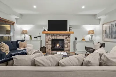 a living room with a couch and a fireplace at Spacious 2bed with Hot Tub in Canmore