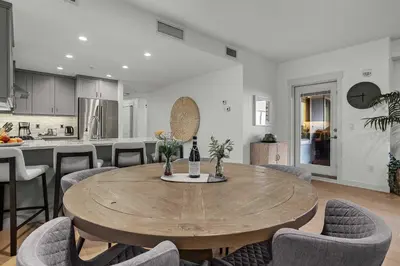 a kitchen and dining room with a wooden table and chairs at Spacious 2bed with Hot Tub in Canmore
