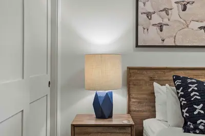 a bedroom with a bed and a table with a lamp at Spacious 2bed with Hot Tub in Canmore