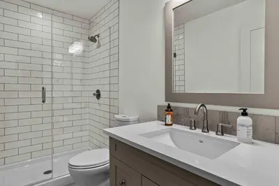 a bathroom with a sink and a toilet and a mirror at Spacious 2bed with Hot Tub in Canmore