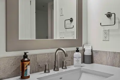 a bathroom sink with a mirror and a bottle of soap at Spacious 2bed with Hot Tub in Canmore