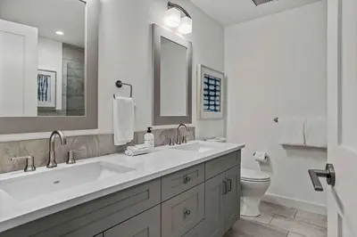 a white bathroom with a sink and a toilet at Spacious 2bed with Hot Tub in Canmore