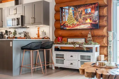 a kitchen with a christmas painting on the wall at The View Point Lodge Cozy Log House with Hot Tub in Vernon