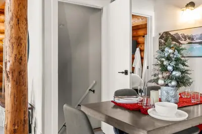 a dining room with a table with a christmas tree at The View Point Lodge Cozy Log House with Hot Tub in Vernon