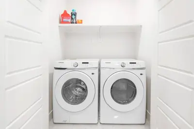 a white laundry room with a washer and dryer at Luxury Family Home - Sleeps 10 - King Bed in Nisku