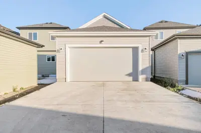 a house with a white garage door in a driveway at Luxury Family Home - Sleeps 10 - King Bed in Nisku