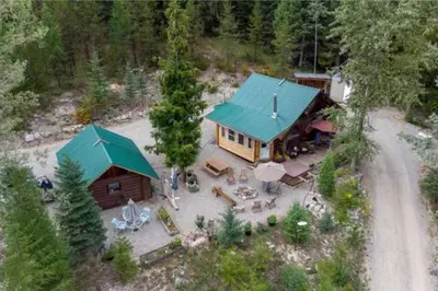 an aerial view of a log cabin with a green roof at Authentic lofted log cabin with hot tub in Kelowna