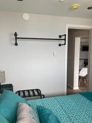 a bedroom with a bed with a rail on the wall at Lakefront Nest Beach House Suite in Penticton