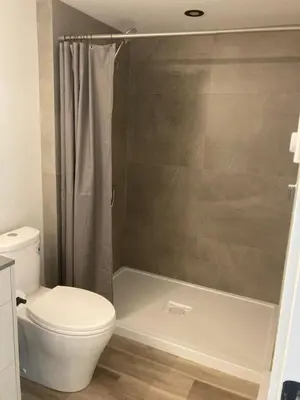 a bathroom with a toilet and a shower at Lakefront Nest Beach House Suite in Penticton