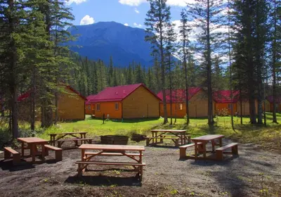 a group of picnic tables in front of a cabin at Jasper East Cabins in Jasper