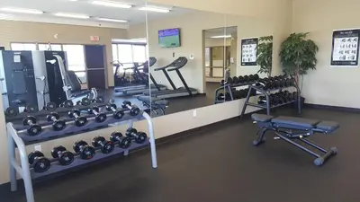a gym with a lot of treadmills and weights at Microtel Inn & Suites by Wyndham Whitecourt in Whitecourt