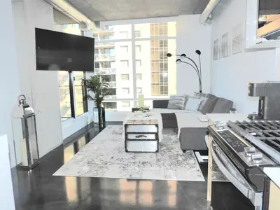 a white living room with a couch and a table at Modern Cozy Nest in Calgary