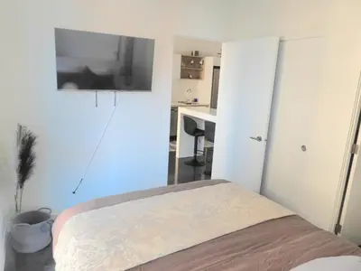 a bedroom with a bed and a tv on the wall at Modern Cozy Nest in Calgary