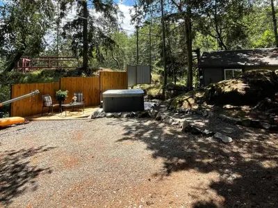 a backyard with a hot tub and a fence at Cozy Cabana with Large Private Outdoor Hot Tub in Nanoose Bay