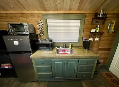 a kitchen with a sink and a microwave and a refrigerator at Cozy Cabana with Large Private Outdoor Hot Tub in Nanoose Bay