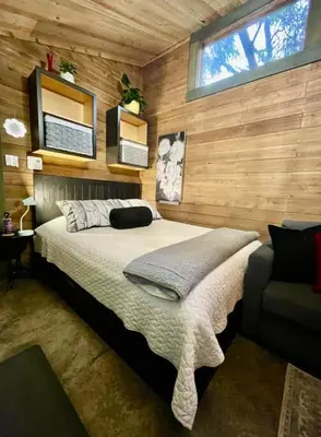 a bedroom with a bed in a wooden wall at Cozy Cabana with Large Private Outdoor Hot Tub in Nanoose Bay