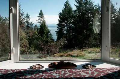 a large window with a view of the ocean at Oceanview Guest Suite with Large 2 Person Soaker Tub in Nanoose Bay