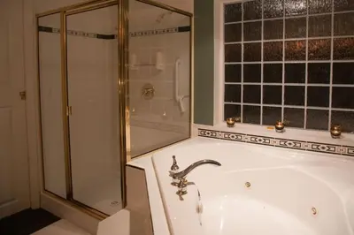 a bathroom with a shower and a white tub at Oceanview Guest Suite with Large 2 Person Soaker Tub in Nanoose Bay