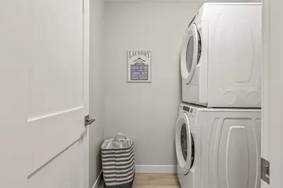a white laundry room with a washer and dryer at Elevated Mountain Living 2BD Spring Creek Unit in Canmore