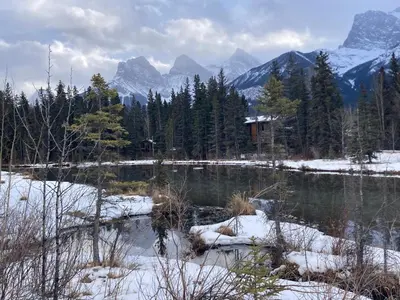 a view of a lake with snow covered mountains at Elevated Mountain Living 2BD Spring Creek Unit in Canmore
