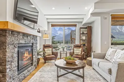 a living room with a couch and a fireplace at Elevated Mountain Living 2BD Spring Creek Unit in Canmore
