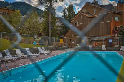 a swimming pool with chairs and a house at Horsethief Lodge by StayIn in Panorama