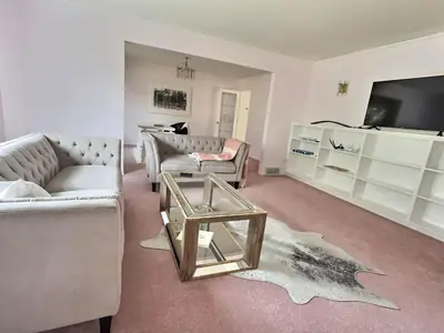a living room with couches and a table and a tv at Blush Bliss A Peaceful Vineyard Escape in Keremeos