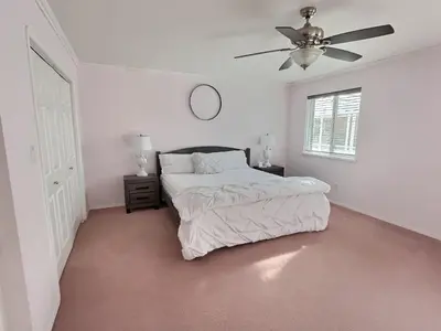 a white bedroom with a bed and a ceiling fan at Blush Bliss A Peaceful Vineyard Escape in Keremeos