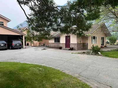 a house with a red door and a driveway at Taurean Vines Guest house in Keremeos