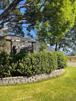 a stone retaining wall with a gazebo in a park at Taurean Vines Guest house in Keremeos