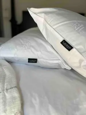 a white bed with two pillows on top of it at Taurean Vines Guest house in Keremeos