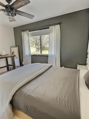 a bedroom with a large bed with a window at Taurean Vines Guest house in Keremeos