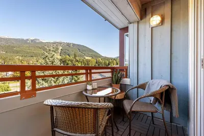 a balcony with chairs and a table with a view at Location with Views - 2BDR Penthouse Whistler Village in Whistler