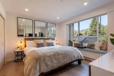 a bedroom with a large bed and a large window at Location with Views - 2BDR Penthouse Whistler Village in Whistler